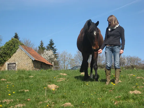 Karine Gueau dans un champ avec une jument pour la découverte du cheval pour les non-cavaliers