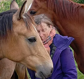 Karine Grueau, au milieu de plusieurs chevaux.Elle se porte garante du bien-être animalier en Normandie